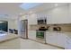 Well-lit kitchen featuring stainless steel appliances, granite countertops, white cabinets, and a skylight at 8138 E Via De La Escuela --, Scottsdale, AZ 85258