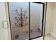 A glass-enclosed shower with pebble flooring and garden-themed decorative accents at 8138 E Via De La Escuela --, Scottsdale, AZ 85258