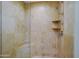 Shower stall with stone-tiled walls, glass door, shelving, and shower head at 8138 E Via De La Escuela --, Scottsdale, AZ 85258