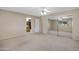 Neutral bedroom showcasing carpet, ceiling fan, access to the bathroom, and mirrored closet at 829 S Revolta Cir, Mesa, AZ 85208