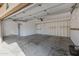 Spacious garage with white painted walls, white door to enter the home, and concrete floor at 829 S Revolta Cir, Mesa, AZ 85208