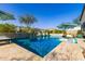 Beautiful swimming pool with stone accents, waterfall features, lush landscaping, and a sun umbrella at 834 E Kachina Trl, Phoenix, AZ 85042