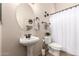 Powder room featuring a pedestal sink, toilet, and decor at 9260 E Greenway St, Mesa, AZ 85207