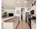 Bright kitchen with white cabinets, black appliances, and a view of the living area at 9260 E Greenway St, Mesa, AZ 85207