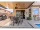 Covered outdoor patio with ceiling fan and dining table, connected to the home and swimming pool at 9260 E Greenway St, Mesa, AZ 85207