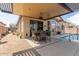 Covered patio featuring an outdoor table set next to a pool and desert landscaping at 9260 E Greenway St, Mesa, AZ 85207