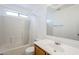 Bright bathroom featuring a bathtub with tile surround and vanity with a large mirror at 9405 W Palmer Dr, Peoria, AZ 85345