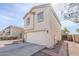 View of the side of a two story home with beige stucco, a two car garage, and a fenced side yard at 9405 W Palmer Dr, Peoria, AZ 85345