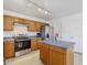 Well-lit kitchen featuring a stainless steel oven, blue countertops, wood cabinets, and a kitchen island at 9405 W Palmer Dr, Peoria, AZ 85345