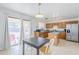 Bright eat-in kitchen featuring wood cabinets, an island, stainless steel appliances, and sliding glass doors to the backyard at 9405 W Palmer Dr, Peoria, AZ 85345