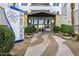 Inviting entrance with lush landscaping, a decorative compass sign, and a welcoming pathway to the building at 945 E Playa Del Norte Dr # 5005, Tempe, AZ 85288