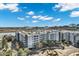 Modern apartment complex showcasing balconies, landscaping, and roundabout with water views under a sunny, cloudy sky at 945 E Playa Del Norte Dr # 5005, Tempe, AZ 85288