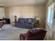 Cozy living room featuring plush carpet, ample seating, and a large window for natural light at 10013 W Alabama Ave, Sun City, AZ 85351