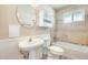 Bathroom featuring pedestal sink, large mirror and tiled bath and shower at 10025 W Alabama Ave, Sun City, AZ 85351