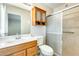 Bathroom featuring a tiled shower, wood cabinet and framed mirror at 10025 W Alabama Ave, Sun City, AZ 85351