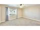 A cozy bedroom featuring neutral carpet, a ceiling fan, and a bright window with curtains at 10025 W Alabama Ave, Sun City, AZ 85351