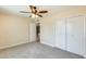 Carpeted bedroom with ceiling fan, closet and doorway to next room at 10025 W Alabama Ave, Sun City, AZ 85351