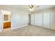 Bright bedroom with carpet flooring, a ceiling fan, and a view into the ensuite bathroom at 10025 W Alabama Ave, Sun City, AZ 85351