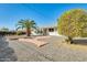 View of the home's front yard with mature landscaping, featuring a small deck and desert landscaping at 10025 W Alabama Ave, Sun City, AZ 85351