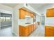 Well-lit kitchen with sleek, gray wood-look floors, natural wood cabinets, and white tile countertops at 10025 W Alabama Ave, Sun City, AZ 85351