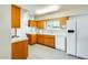 Well-lit kitchen featuring wood cabinetry, white appliances, modern floors, and bright light fixtures at 10025 W Alabama Ave, Sun City, AZ 85351