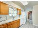 Bright kitchen features wood cabinets, white appliances, tile countertops, and gray wood-look flooring at 10025 W Alabama Ave, Sun City, AZ 85351