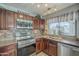 Functional kitchen with modern appliances, dark wood cabinets, and a mosaic tile backsplash at 10115 E Mountain View Rd # 2042, Scottsdale, AZ 85258