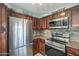 Well-lit kitchen boasts stainless steel appliances and abundant dark wood cabinetry at 10115 E Mountain View Rd # 2042, Scottsdale, AZ 85258