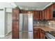 Kitchen featuring stainless steel refrigerator and plenty of dark wood cabinet storage at 10115 E Mountain View Rd # 2042, Scottsdale, AZ 85258