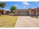 Charming home with a two-car garage, American flag, and desert landscaping at 10127 E Minnesota Ave, Sun Lakes, AZ 85248