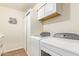 Bright laundry room featuring a washer, dryer, built-in cabinets, and storage closet at 10127 E Minnesota Ave, Sun Lakes, AZ 85248