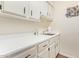 Bright laundry room featuring shaker cabinets, stainless steel sink and laminate countertops at 10127 E Minnesota Ave, Sun Lakes, AZ 85248