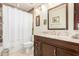 Bathroom with a large mirror, marble counters, and shower with white curtain at 10337 E Michigan Ave, Sun Lakes, AZ 85248