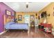 Colorful bedroom featuring wood floors, TV, and eclectic decor at 10337 E Michigan Ave, Sun Lakes, AZ 85248