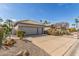 Attractive home exterior boasting a spacious driveway, desert landscaping, and an attached two-car garage at 10337 E Michigan Ave, Sun Lakes, AZ 85248