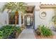 Home's entrance featuring decorative glass door, desert plants, and a quaint bird feeder at 10337 E Michigan Ave, Sun Lakes, AZ 85248