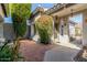 Covered entry courtyard featuring brick and concrete flooring, decorative lighting and mature foliage at 10337 E Michigan Ave, Sun Lakes, AZ 85248