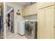 Laundry room featuring stainless steel washer and dryer, and cream cabinets at 10337 E Michigan Ave, Sun Lakes, AZ 85248