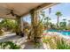 Covered patio featuring lush plants, greenery, and views of the pool and backyard at 10337 E Michigan Ave, Sun Lakes, AZ 85248