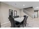 Dining room features a modern table with six chairs, neutral walls, and a view of the staircase at 10428 S 54Th Ln, Laveen, AZ 85339