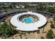 Stunning aerial view of a round building with a pool and large white roof in a community with lush landscaping and parking at 10511 W Edgewood Dr, Sun City, AZ 85351