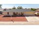 Cozy home with red rock landscaping, inviting front porch seating, and a two-car garage at 10511 W Edgewood Dr, Sun City, AZ 85351