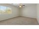 Cozy bedroom with neutral carpet, ceiling fan, and a large window at 10616 E Carol Ave, Mesa, AZ 85208