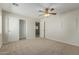 Spacious bedroom with neutral carpet, ceiling fan, and closet with sliding doors at 10616 E Carol Ave, Mesa, AZ 85208