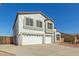 Side view of a charming two-story home featuring a three-car garage, landscaped front yard, and stucco finish at 10616 E Carol Ave, Mesa, AZ 85208