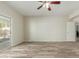 Open living room featuring wood-look flooring, sliding door, and a ceiling fan at 10616 E Carol Ave, Mesa, AZ 85208