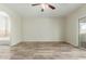 Open living room features wood floors, ceiling fan, and access to a full bathroom at 10616 E Carol Ave, Mesa, AZ 85208