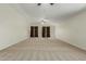 Expansive carpeted living room featuring high ceilings, ceiling fans, and elegant window coverings at 10616 E Carol Ave, Mesa, AZ 85208