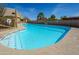 A clear blue swimming pool is surrounded by desert flora and bright blue sky at 11011 N Zephyr Dr # 106, Fountain Hills, AZ 85268