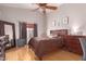 Cozy bedroom with a ceiling fan, a large bed, and hardwood floors at 11178 W Echo Ln, Peoria, AZ 85345